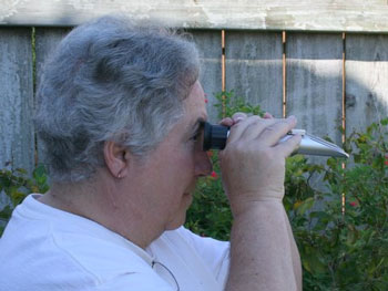 Newfield uses a refractometer to measure flower nectar.